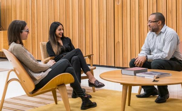 People having a conversation in an office common area People having a conversation in an office common area